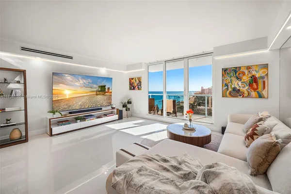 a living room with furniture kitchen view and a large window