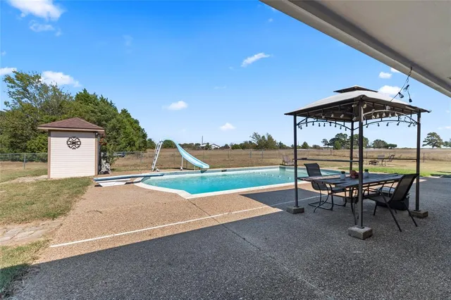 a view of a patio with a table and chairs under an umbrella