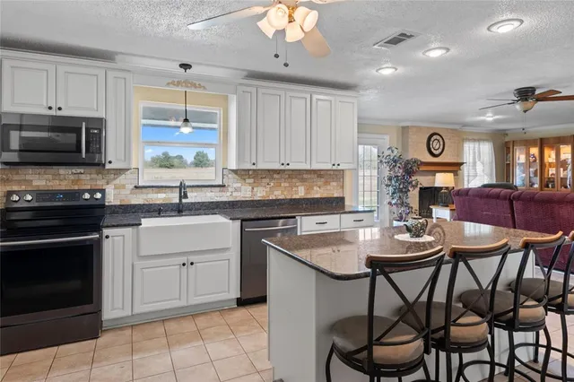 a kitchen with stainless steel appliances granite countertop a refrigerator and a stove top oven