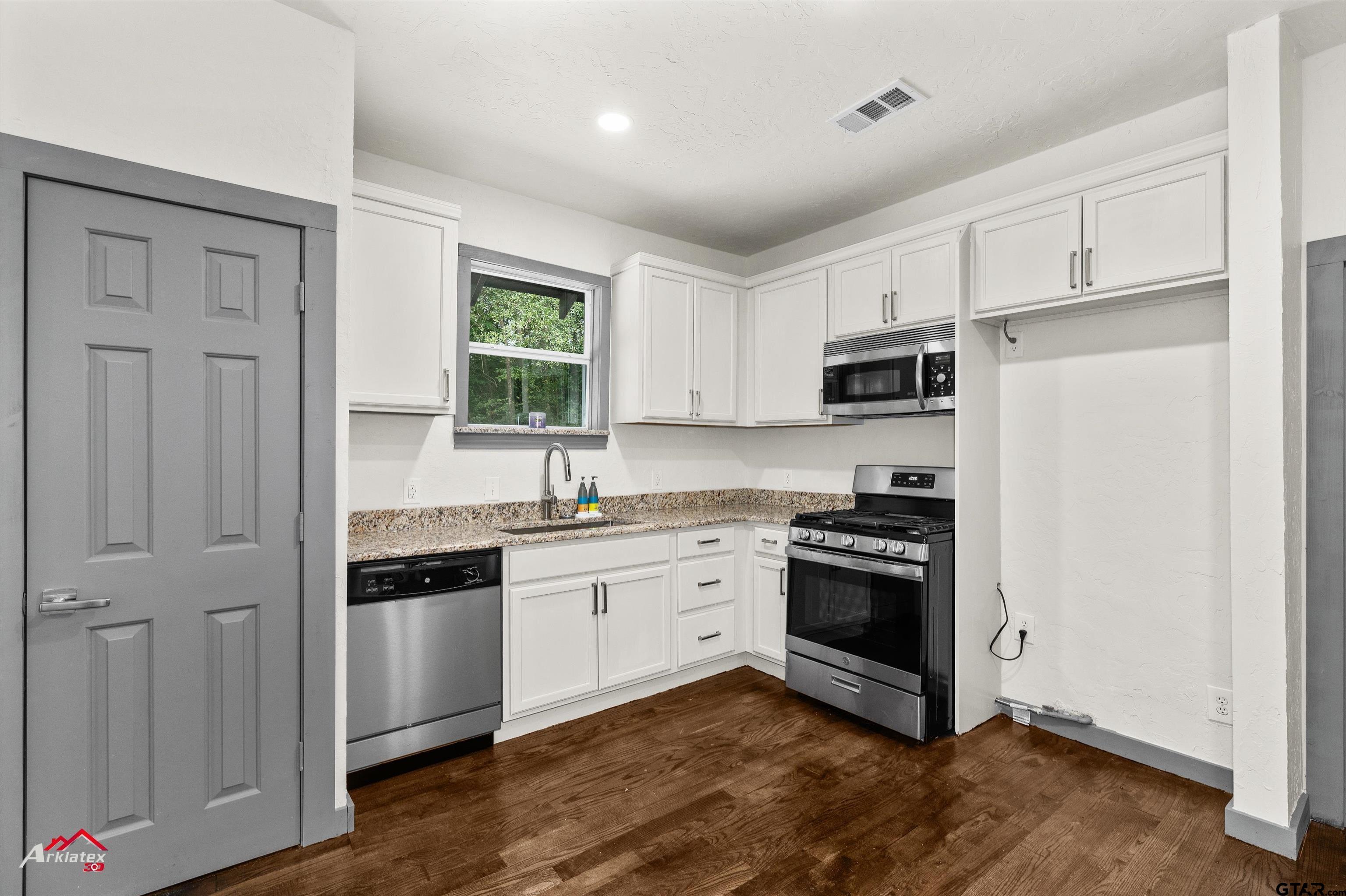 200 Jenkins Street Henderson, TX 75652 - Photo 15 of 25 a kitchen with cabinets stainless steel appliances and a window