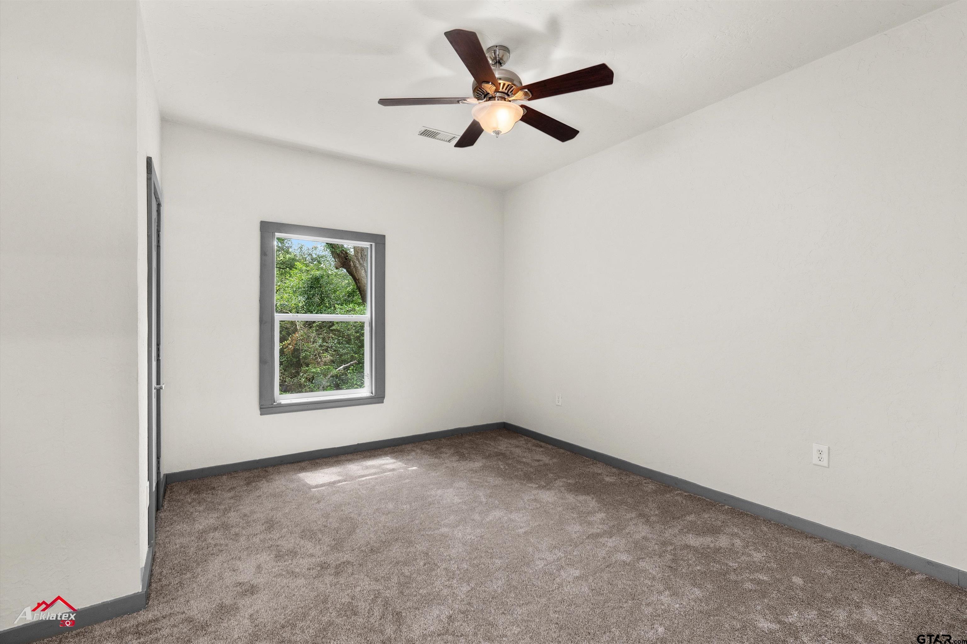200 Jenkins Street Henderson, TX 75652 - Photo 18 of 25 an empty room with a window and a fan