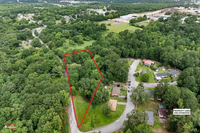 an aerial view of residential house with outdoor space and trees all around