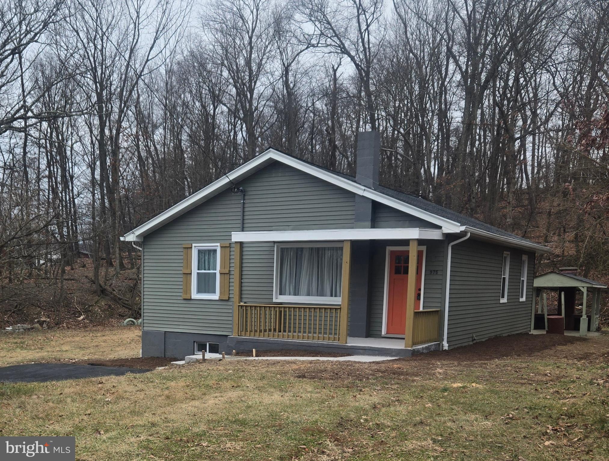 a front view of house with yard and trees in the background