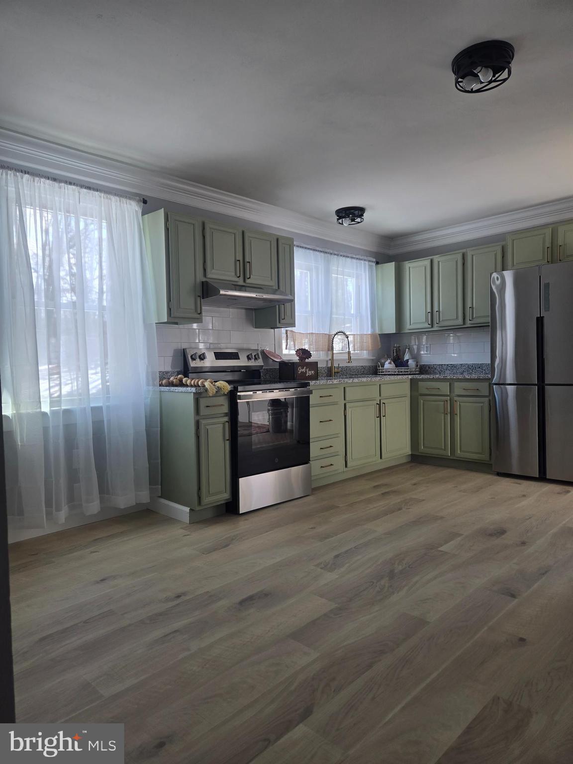 975 Williams Street Cumberland, MD 21502 - Photo 7 of 33 a kitchen with stainless steel appliances granite countertop a stove top oven a refrigerator and a granite counter tops with wooden floors
