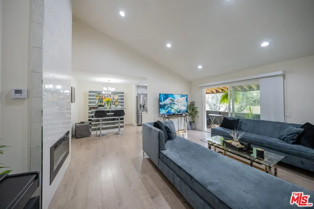 a living room with furniture a flat screen tv and a large window