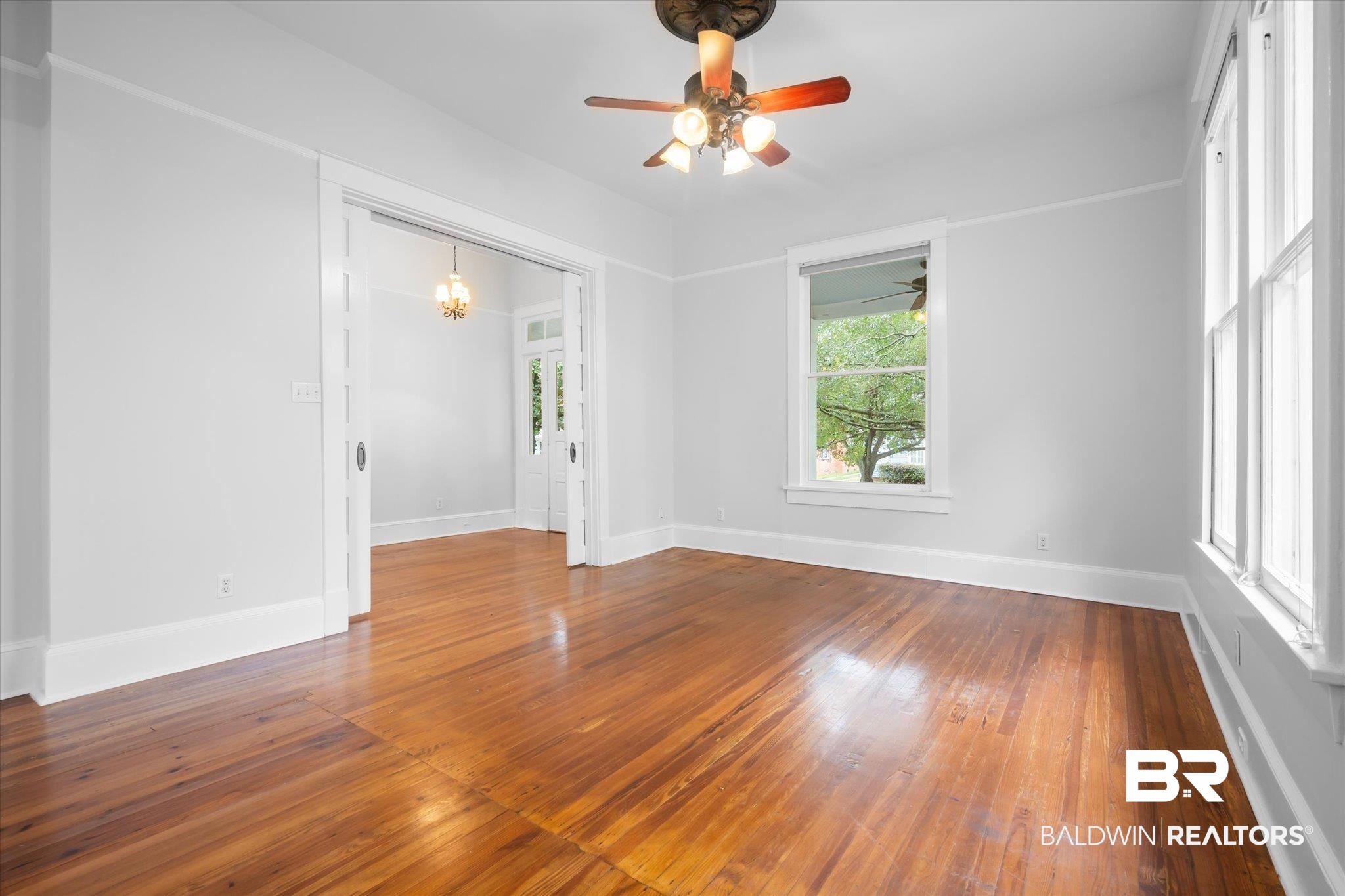 14 South Monterey Street Mobile, AL 36604 - Photo 4 of 41 Spare room featuring ceiling fan with notable chandelier and wood-type flooring