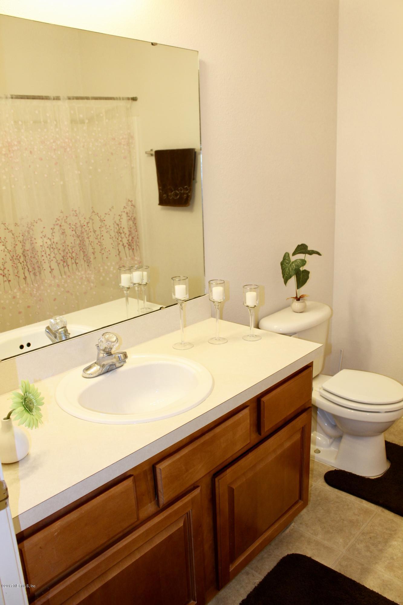 7920 Merrill Road, Unit 1705 Jacksonville, FL 32277 - Photo 16 of 25 a bathroom with a sink a toilet and mirror