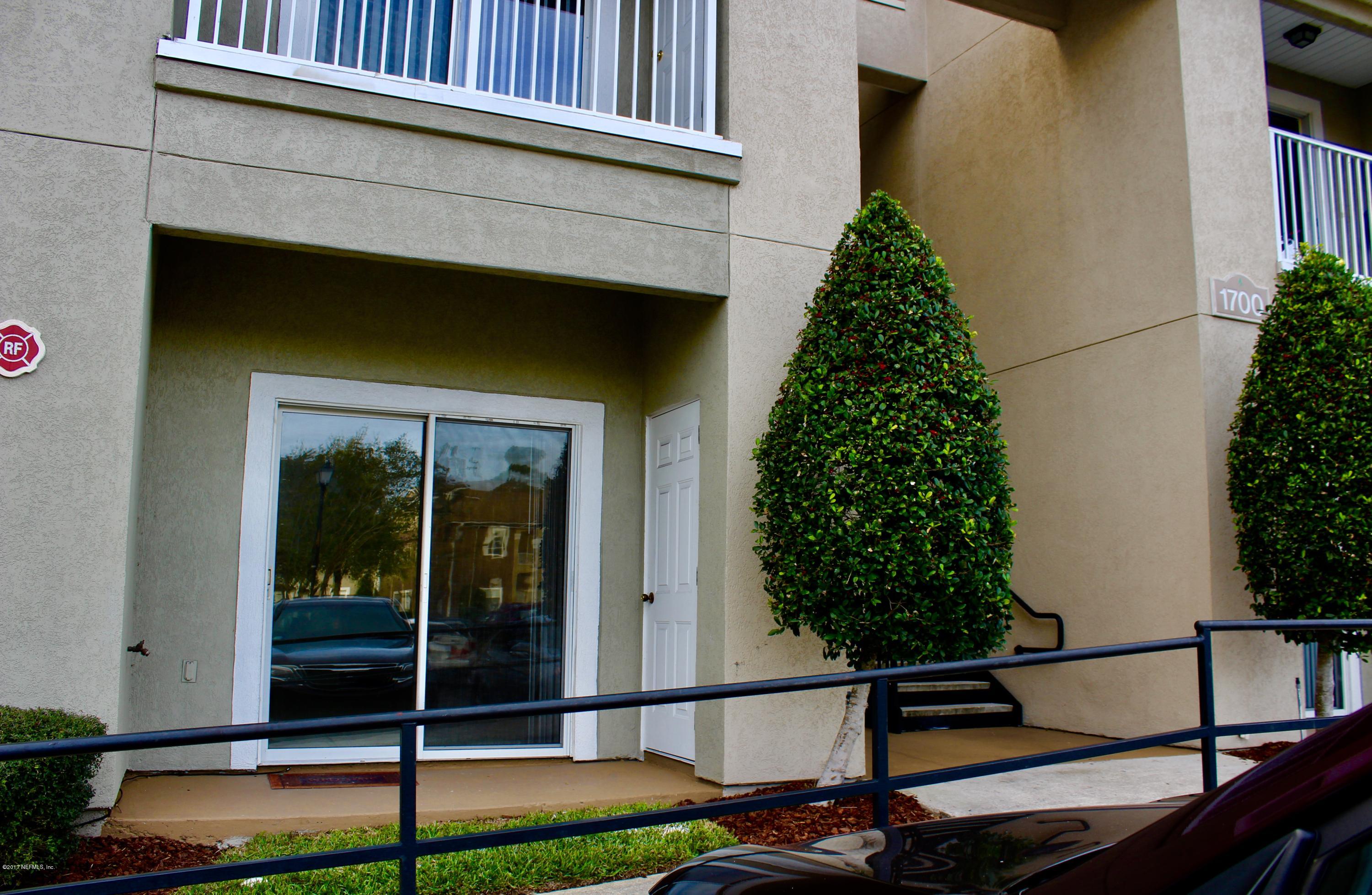 7920 Merrill Road, Unit 1705 Jacksonville, FL 32277 - Photo 18 of 25 a backyard of a house with table and chairs