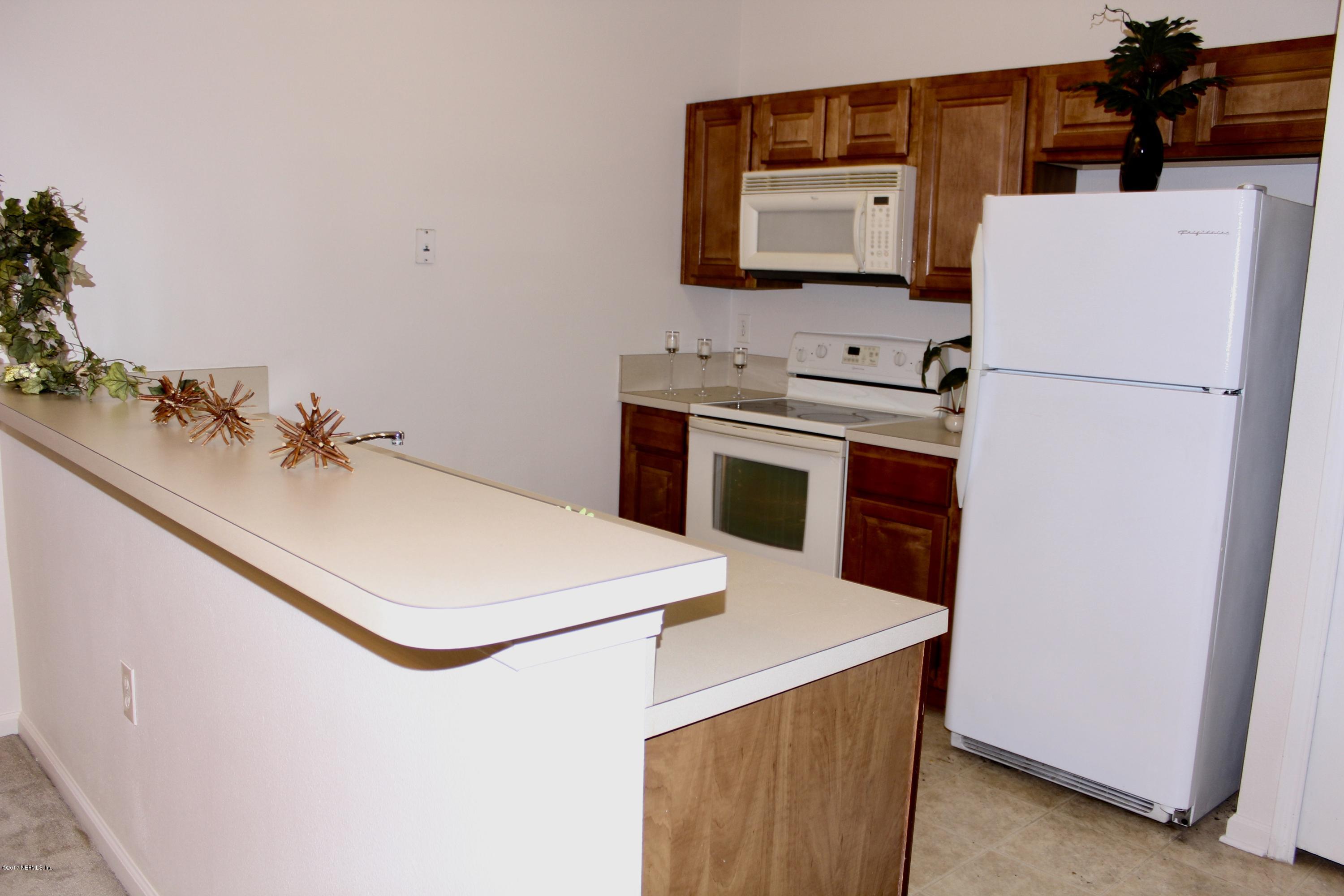 7920 Merrill Road, Unit 1705 Jacksonville, FL 32277 - Photo 7 of 25 a white refrigerator freezer sitting in a kitchen
