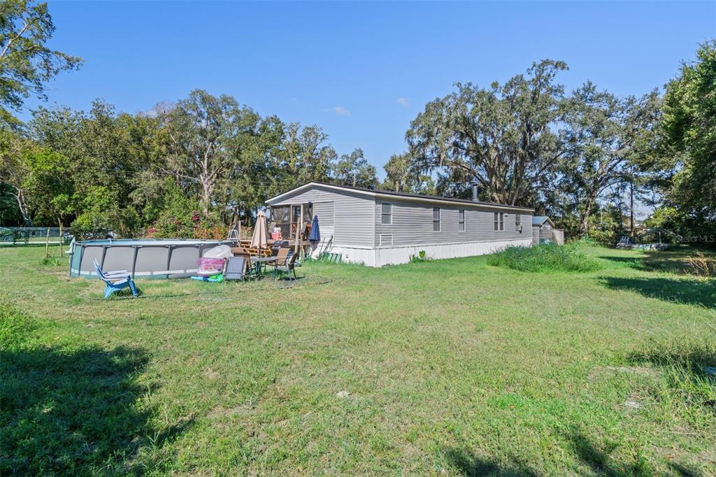 460 Korbus Road Brooksville, FL 34604 - Photo 21 of 22 a backyard of a house with plants and large tree