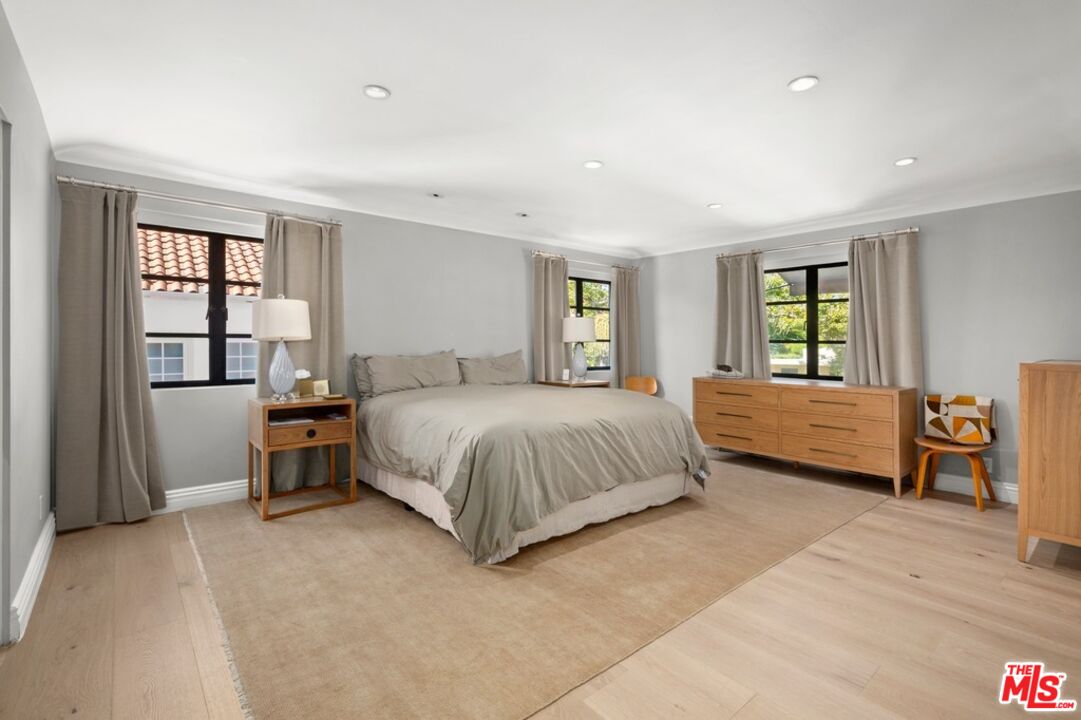 232 South Rodeo Drive Beverly Hills, CA 90212 - Photo 12 of 14 a spacious bedroom with a large bed and a window