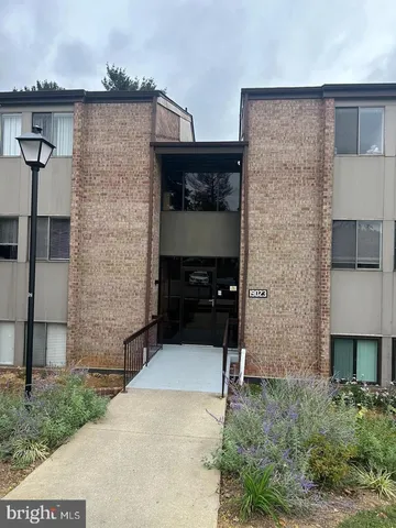 front view of a brick house with a small yard