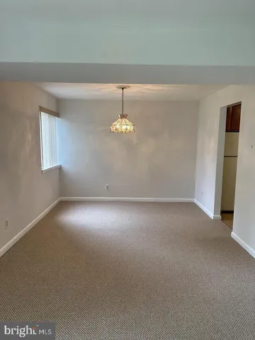 an empty room with windows and chandelier