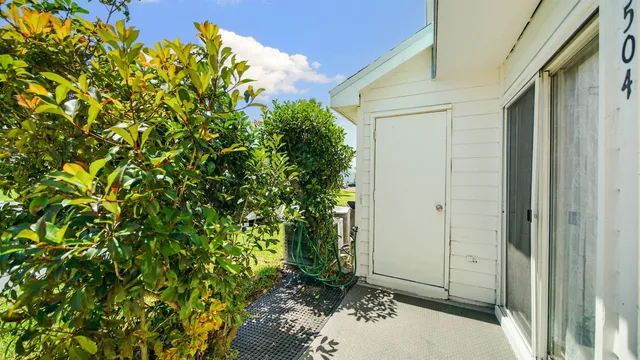 a view of an empty room with window and chandelier fan
