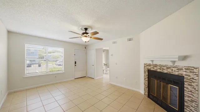 an empty room with windows and fireplace