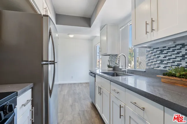 a kitchen with stainless steel appliances granite countertop a refrigerator and a sink