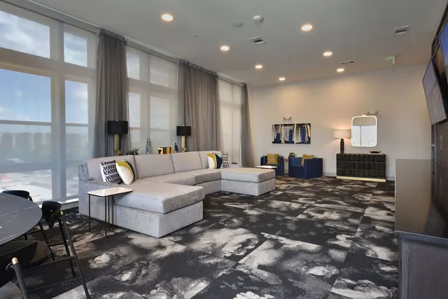 a living room with a large window and a rug