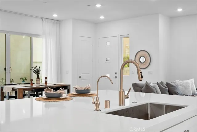 a kitchen with stainless steel appliances granite countertop a sink and white cabinets with wooden floor