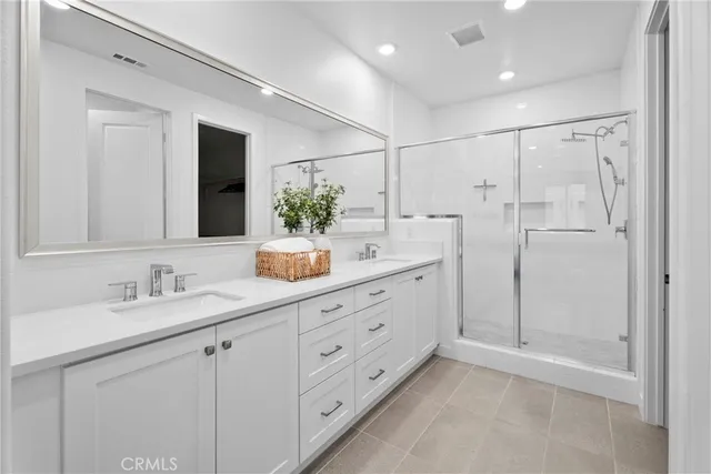 a bathroom with a double vanity sink mirror and shower