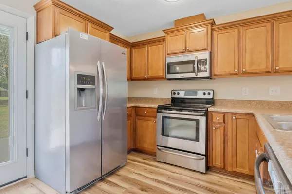 a kitchen with stainless steel appliances granite countertop a refrigerator stove and sink