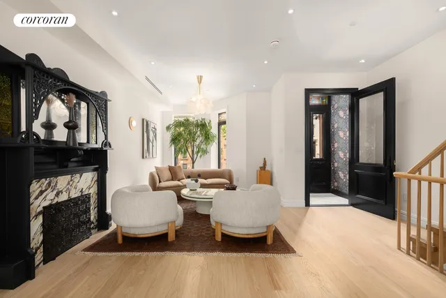 a living room with furniture a fireplace and a potted plant