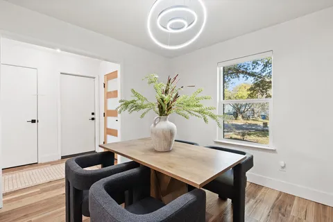 a living room with furniture flowerpot and a chandelier