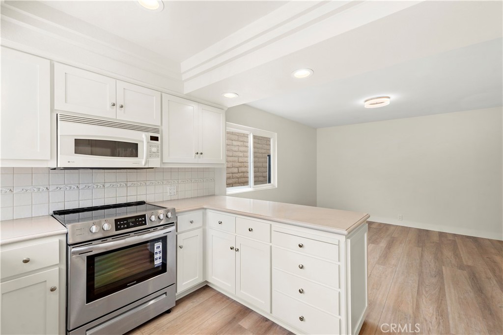 23892 Taranto Bay Dana Point, CA 92629 - Photo 7 of 54 a kitchen with white cabinets stainless steel appliances and sink