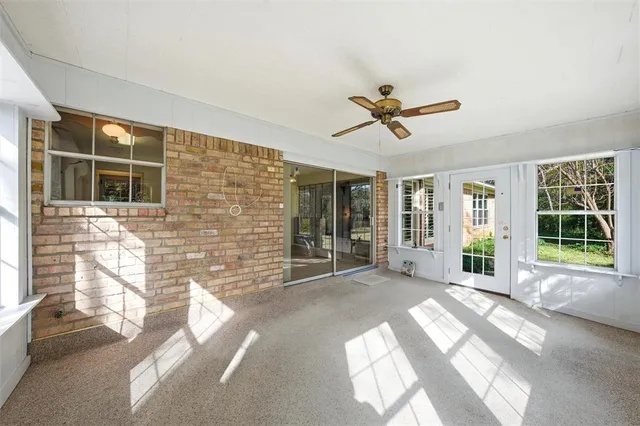 a view of a livingroom with a ceiling fan and window