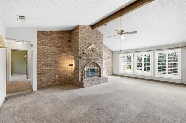 en empty room with windows and ceiling fan