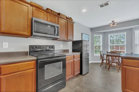 a kitchen with stainless steel appliances granite countertop a stove microwave refrigerator sink and cabinets