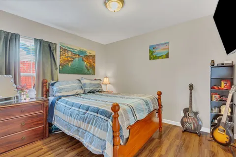 a bedroom with bed and a flat tv screen on dresser