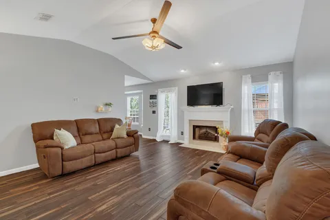 a living room with furniture a fireplace and a flat screen tv