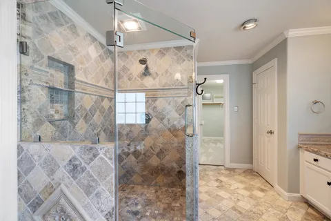 a bathroom with a glass shower door and a bathtub