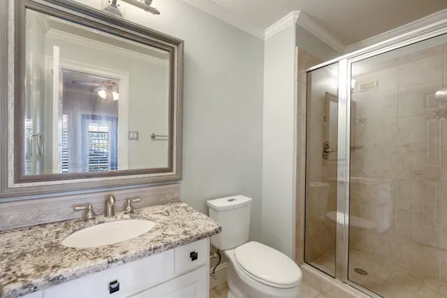 a bathroom with a granite countertop sink toilet a mirror and shower