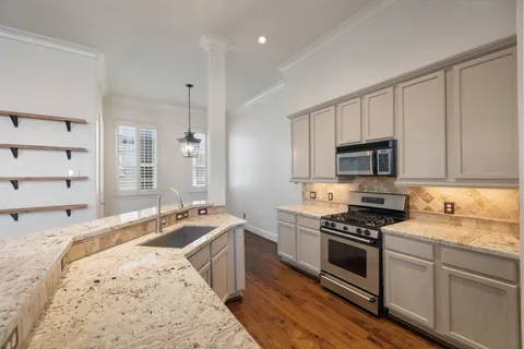 a kitchen with stainless steel appliances granite countertop a stove a sink and a microwave