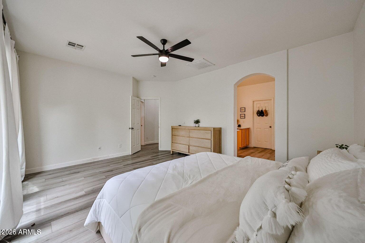 3950 North Edith Way Buckeye, AZ 85396 - Photo 21 of 32 a bedroom with a bed and a chandelier