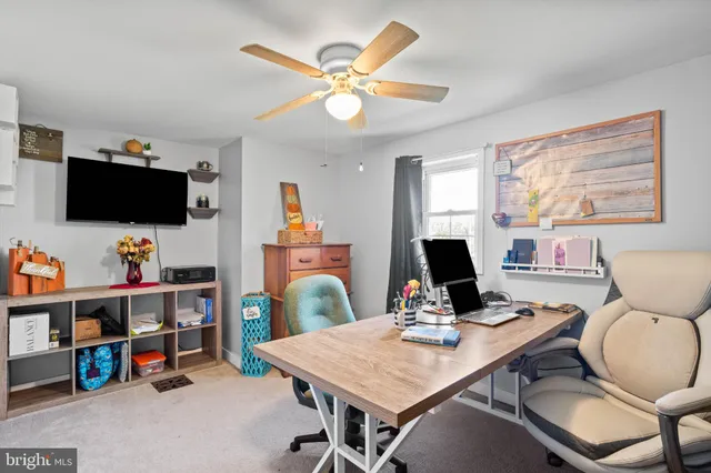a work room with furniture and a flat screen tv