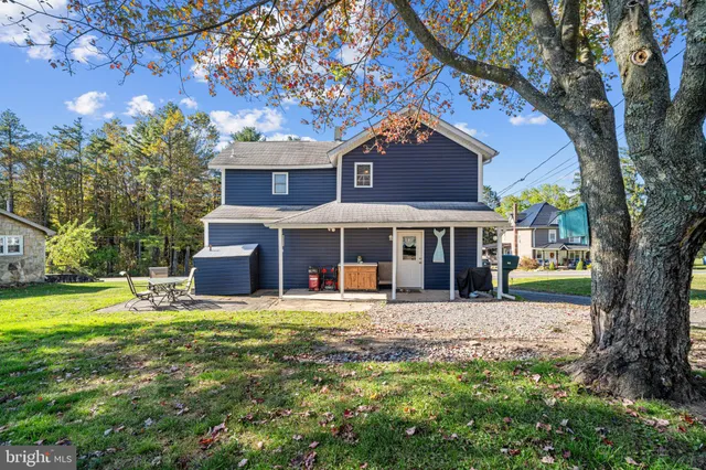 a big house with tall trees in front of it