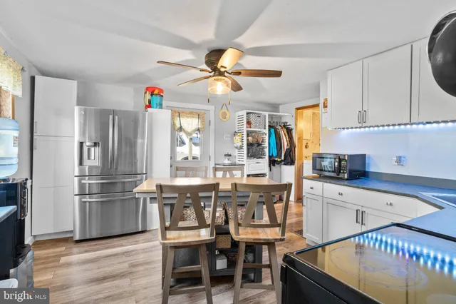 a kitchen with stainless steel appliances granite countertop a sink refrigerator and cabinets