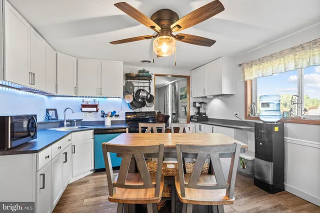 a kitchen with a dining table chairs and white cabinets