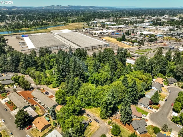 an aerial view of residential houses with outdoor space and trees