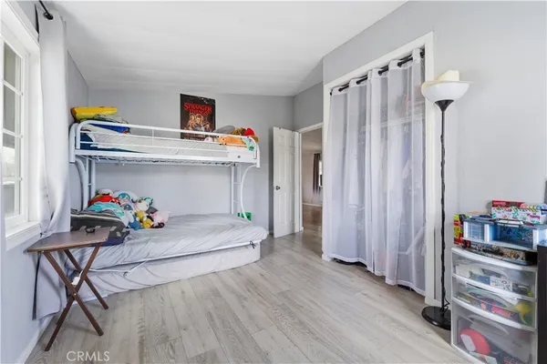 a utility room with closet dryer and wooden floor