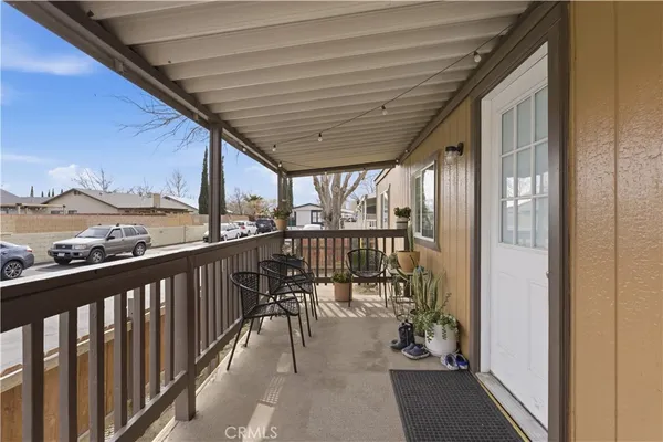 a view of a balcony with chairs and wooden floor