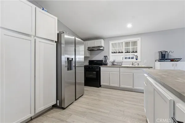 a kitchen with a refrigerator sink and cabinets