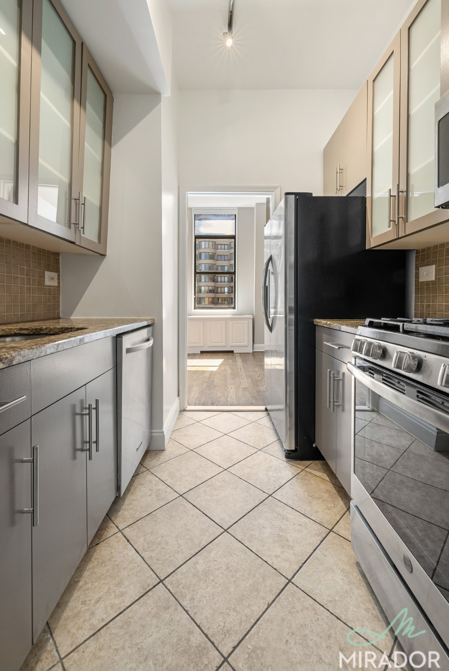 330 East 39th Street, Unit 15C Manhattan, NY 10016 - Photo 5 of 24 a kitchen with stainless steel appliances a refrigerator stove microwave and sink