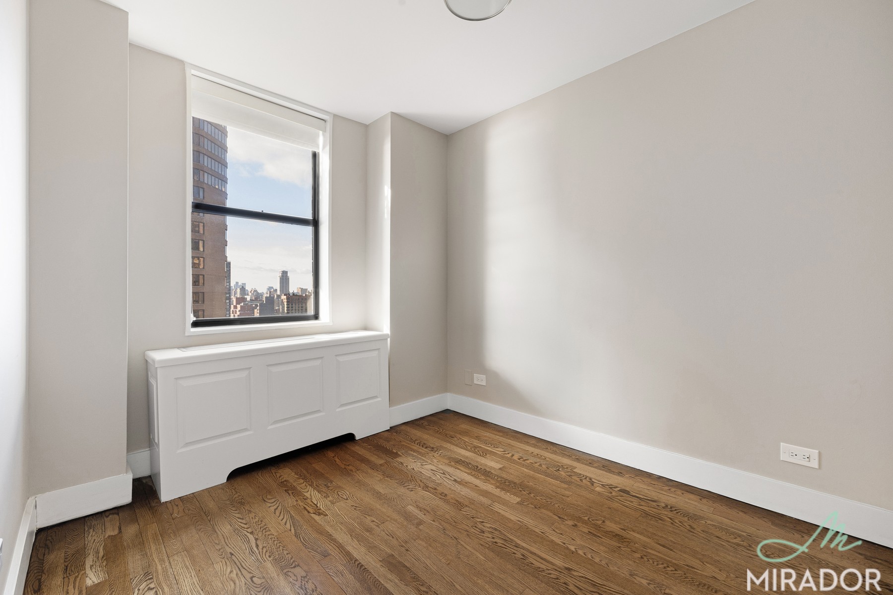330 East 39th Street, Unit 15C Manhattan, NY 10016 - Photo 6 of 24 an empty room with wooden floor and windows