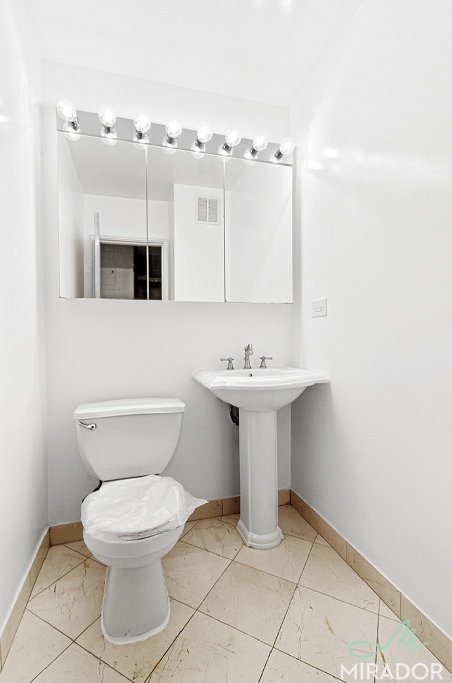 330 East 39th Street, Unit 15C Manhattan, NY 10016 - Photo 8 of 24 a bathroom with a sink toilet and mirror