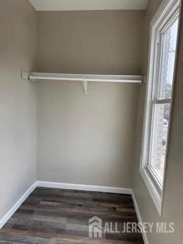 a view of a room with wooden floor and window