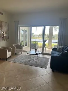 a living room with furniture and a floor to ceiling window