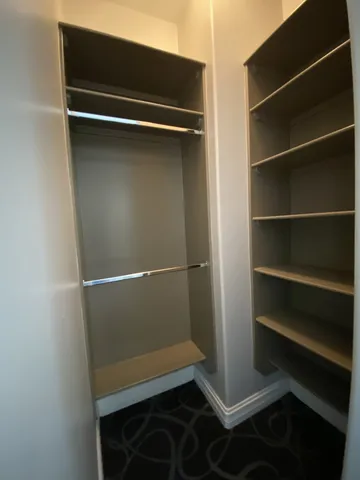 a view of walk in closet with empty racks